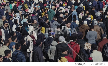 Large crowd gathering and protesting in a public square 122584057