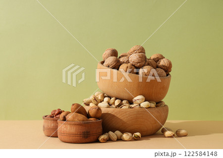 Various nuts in wooden bowls on a light background 122584148