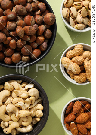 Various nuts in white and black bowls 122584149