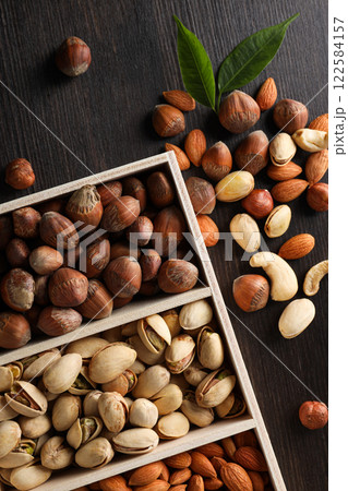Wooden box with different nuts on a dark background Wooden box with different nuts on a dark background 122584157