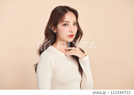 Beautiful young asian woman with clean fresh skin on beige background, Face care, Facial treatment, Cosmetology, beauty and spa, Asian women portrait. Beautiful young asian woman with clean fresh skin on beige background, Face care, Facial treatment, Cosmetology, beauty and spa, Asian women portrait. 122584722