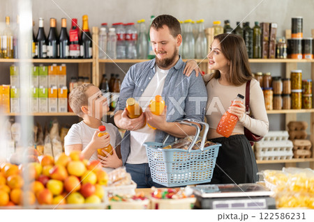 Young family with little son choosing natural juice in supermarket 122586231