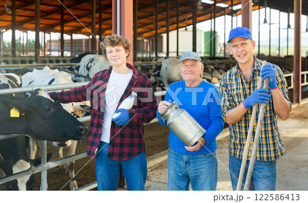 Continuity of generations - portrait of farmers of different ages against the backdrop of cowshed Continuity of generations - portrait of farmers of different ages against the backdrop of cowshed 122586413