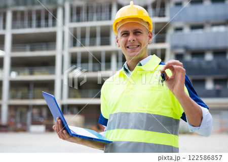 Portrait of a positive man engineer, demonstrating in his hand the keys 122586857