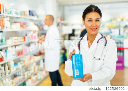Female pharmacist with sanitizer in drugstore 122586902