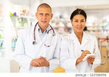 Portrait of two pharmacists - men and women in white coats in pharmacy 122586956