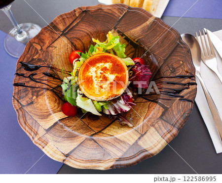 Fried goat cheese salad with vegetables, greens, nuts and raisins Fried goat cheese salad with vegetables, greens, nuts and raisins 122586995