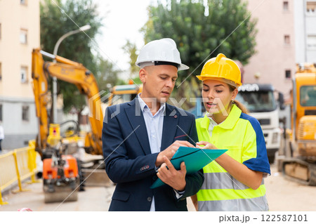 Man and woman engineers in construction site Man and woman engineers in construction site 122587101