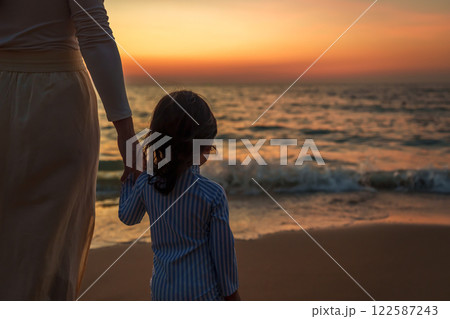mother standing with toddler baby girl on sea beach at sunset in Pattaya, Thailand mother standing with toddler baby girl on sea beach at sunset in Pattaya, Thailand 122587243