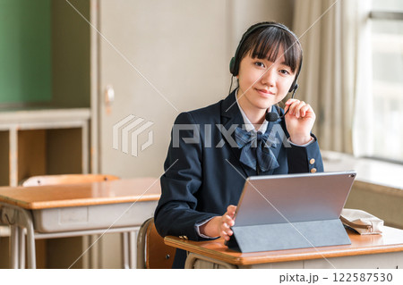 タブレットを使って勉強する制服姿の中学生・高校生の女子生徒（オンライン英会話） 122587530