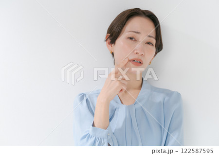顔に手をあてるミドル女性 122587595