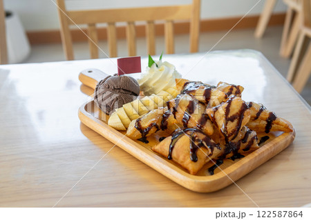 Ice cream chocolate waffle with whipping cream and bananas. 122587864