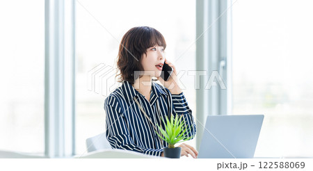 スマホで話す笑顔の女性・ビジネスウーマン 122588069