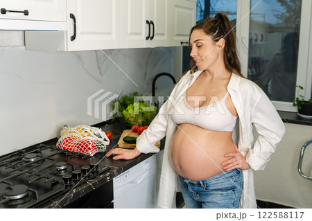 Pregnant Woman Preparing Vegetables in the Kitchen Pregnant Woman Preparing Vegetables in the Kitchen 122588117