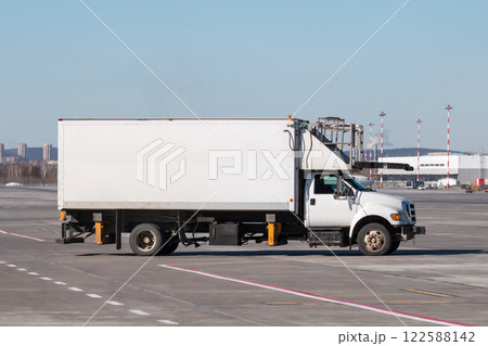 Catering truck for delivery of food to the airplane on the airport apron Catering truck for delivery of food to the airplane on the airport apron 122588142