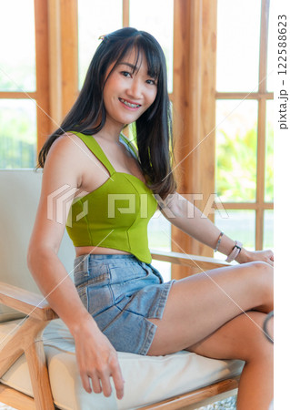 Portrait of beautiful sexy asian woman Wearing a green strapless dress and jean skirt in a cafe Portrait of beautiful sexy asian woman Wearing a green strapless dress and jean skirt in a cafe 122588623