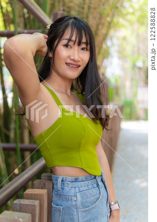 Portrait of beautiful sexy asian woman Wearing a green strapless dress and jean skirt in a cafe Portrait of beautiful sexy asian woman Wearing a green strapless dress and jean skirt in a cafe 122588828