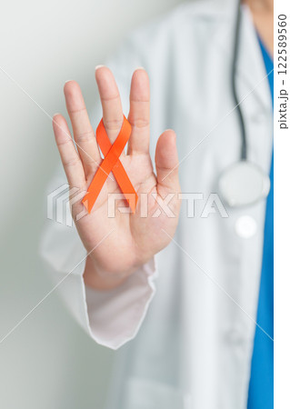 Doctor with Orange Ribbon for Leukemia, Kidney cancer day, world Multiple Sclerosis, CRPS, Self Injury Awareness month. Healthcare and word cancer day concept 122589560