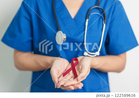 Doctor with Burgundy Red Ribbon for March multiple myeloma Cancer and December World Aids Day Awareness month. Healthcare and world cancer day concept 122589616
