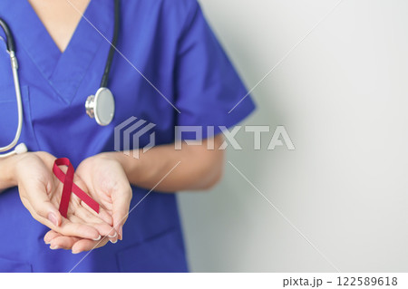 Doctor with Burgundy Red Ribbon for March multiple myeloma Cancer and December World Aids Day Awareness month. Healthcare and world cancer day concept 122589618