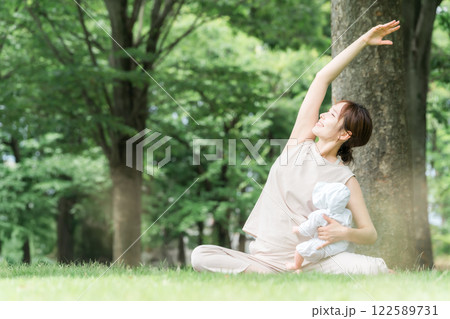 ベビーヨガ・親子ヨガをするママ・母親・若いアジア人女性(ヨガウェア・公園) ベビーヨガ・親子ヨガをするママ・母親・若いアジア人女性(ヨガウェア・公園) 122589731