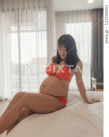 Asia sexy pregnant mother in red bikini in the bedroom Asia sexy pregnant mother in red bikini in the bedroom 122589881