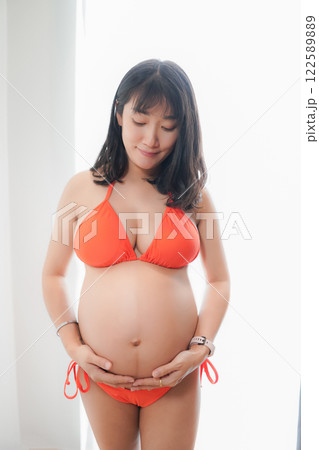 Asia sexy pregnant mother in red bikini in the bedroom 122589889