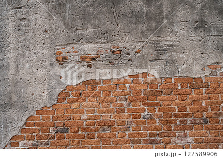 The walls are peeling the red bricks are visible texture background. 122589906
