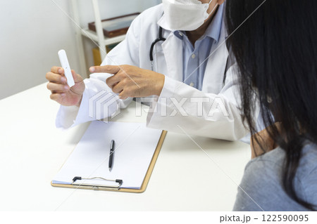 Male doctor show Rapid Antigen Test kit with Negative result to female patient. 122590095