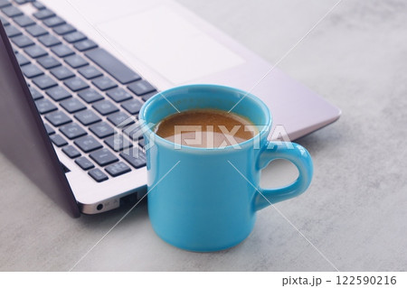 淹れたての美味しいコーヒーを飲みながら、ノートパソコンでデスクワークをしているイメージ 122590216