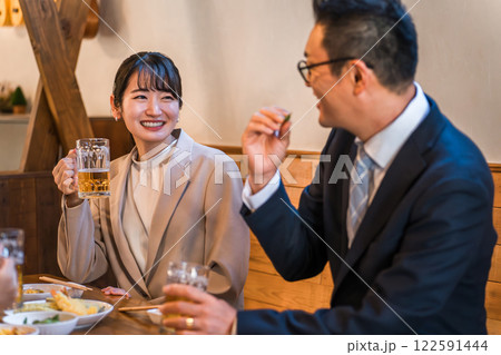 居酒屋・飲み屋で談笑する男女のサラリーマン 122591444