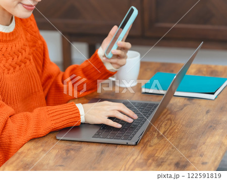 ノートパソコンとスマホを使う女性 122591819