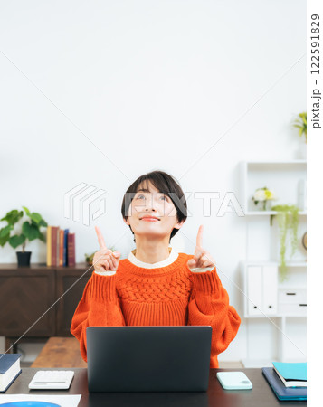 部屋で上を指さすミドル女性 122591829