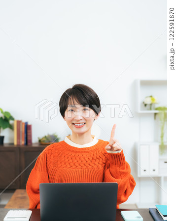 部屋で上を指さすミドル女性 122591870