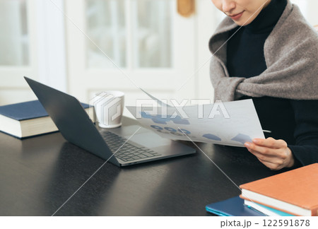 ノートパソコンでデータをチェックするミドル女性 122591878