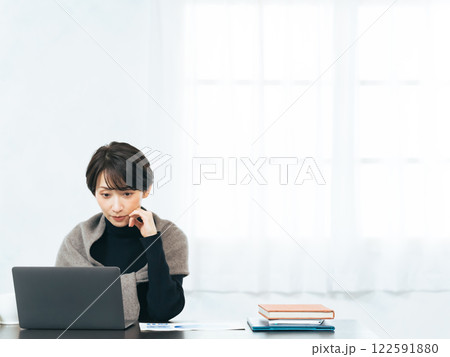 デスクのノートパソコンで作業する女性 デスクのノートパソコンで作業する女性 122591880
