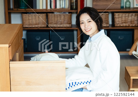 衣類を片付ける若い女性 122592144