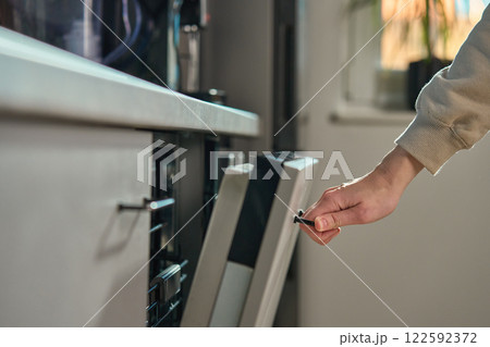 Hand opening dishwasher door in modern kitchen 122592372