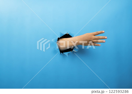 Human hand showing from ripped paper. Hand gestures of counting. Mockup or Copy space. Concept of sign or communication Human hand showing from ripped paper. Hand gestures of counting. Mockup or Copy space. Concept of sign or communication 122593286