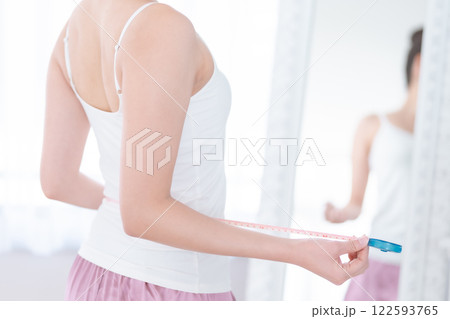 メジャーを手にするダイエット中の女性　顔無し 122593765