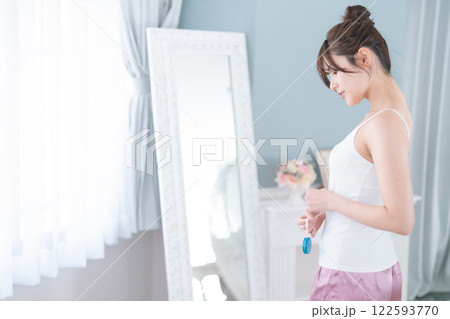 腹囲を図るダイエット中の若い女性 122593770