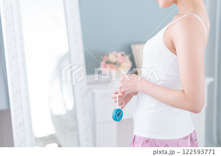 メジャーを手にするダイエット中の女性　顔無し 122593771