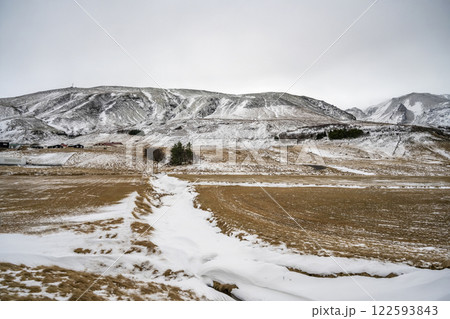 Landscape view of snow covered fields and mountains in Iceland. Nature, travel, winter background, or wallpaper Landscape view of snow covered fields and mountains in Iceland. Nature, travel, winter background, or wallpaper 122593843