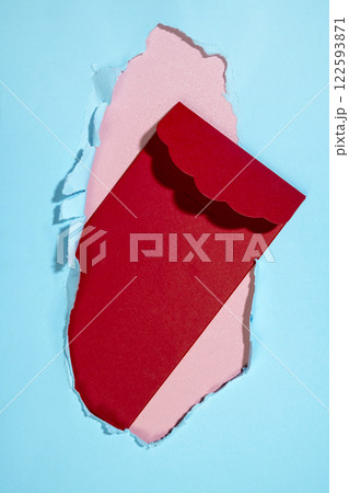 Red envelope from the hole of ripped paper. Mockup or Copy space. Template. Greetings or invitation. Concept of message or communication 122593871