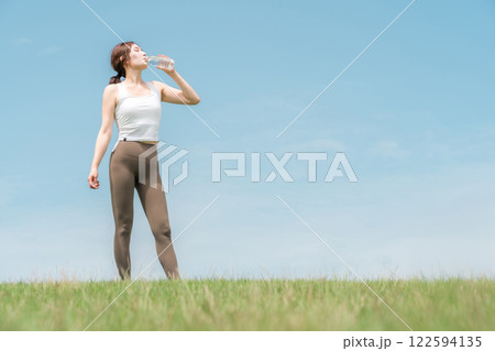 運動時に水を飲む女性（熱中症対策・水分補給・ミネラルウォーター） 122594135