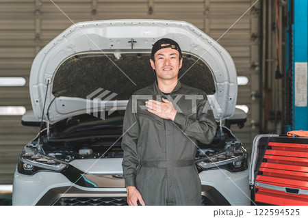 整備工場で働く整備士・自動車整備士・メカニックの中年アジア人男性 整備工場で働く整備士・自動車整備士・メカニックの中年アジア人男性 122594525