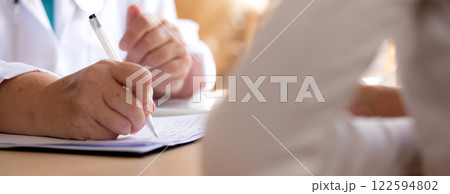 Senior woman doctor consults with young patient in modern medical office, doctor explaining. Senior woman doctor consults with young patient in modern medical office, doctor explaining. 122594802