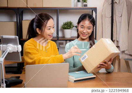 Two asian woman working while planning online business and checking order with writing on tablet. Two asian woman working while planning online business and checking order with writing on tablet. 122594968