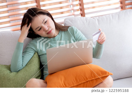 Young asian woman holding credit card or debit card with stress about loan and expense. Young asian woman holding credit card or debit card with stress about loan and expense. 122595188