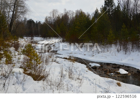 Landscape of a small river in the woods in the winter. River that does not freeze in winter.  122596516